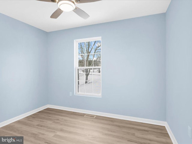 unfurnished room with a ceiling fan, light wood-type flooring, visible vents, and baseboards