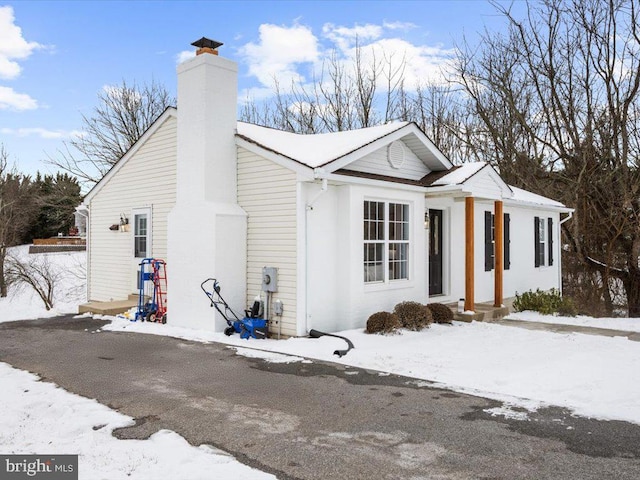 view of snowy exterior featuring a chimney