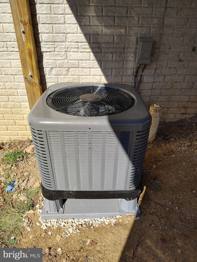 exterior details featuring cooling unit and brick siding