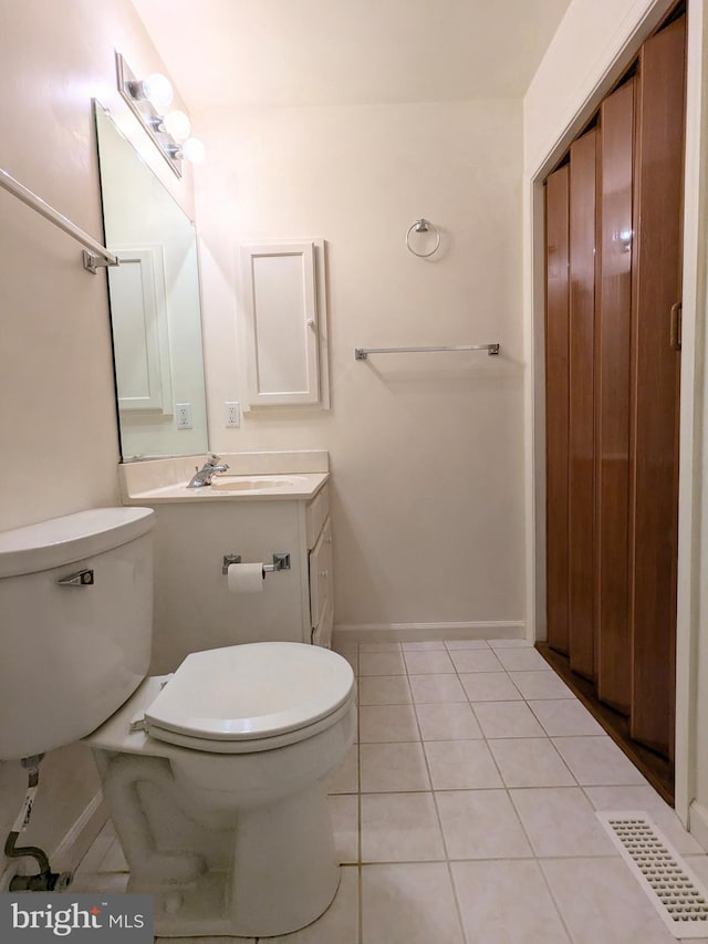 bathroom with vanity, toilet, and tile patterned flooring