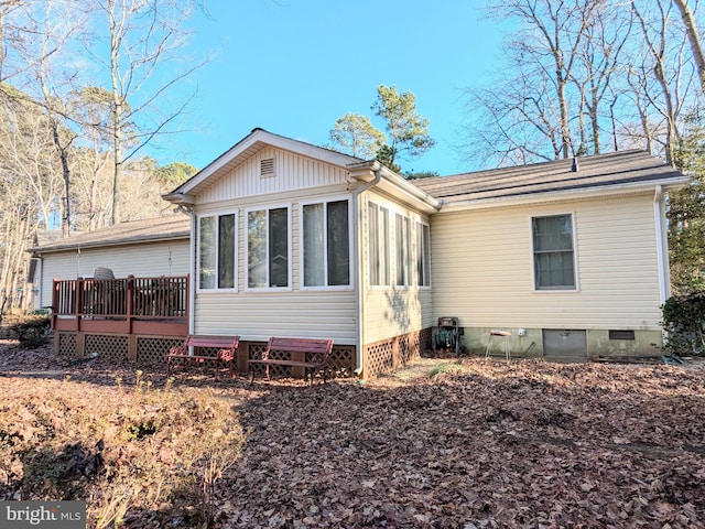 back of property with a deck and a sunroom