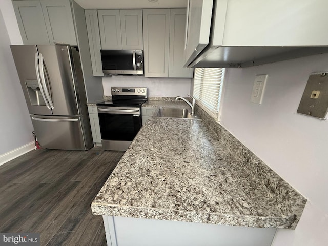 kitchen featuring light stone countertops, dark hardwood / wood-style flooring, stainless steel appliances, sink, and gray cabinets