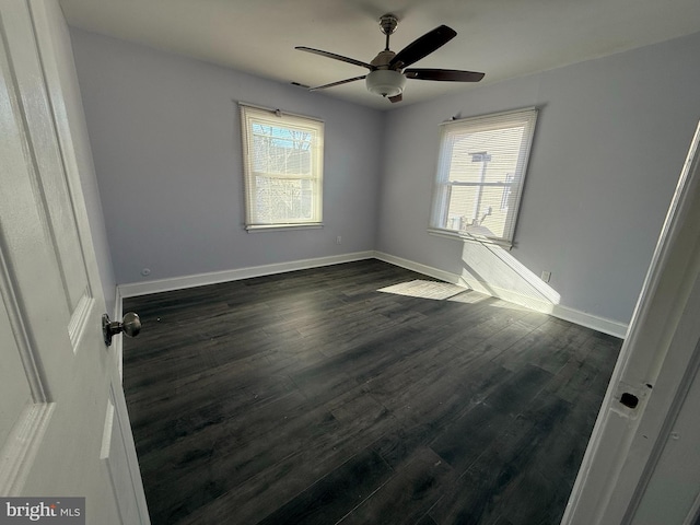 spare room with plenty of natural light, ceiling fan, and dark hardwood / wood-style flooring