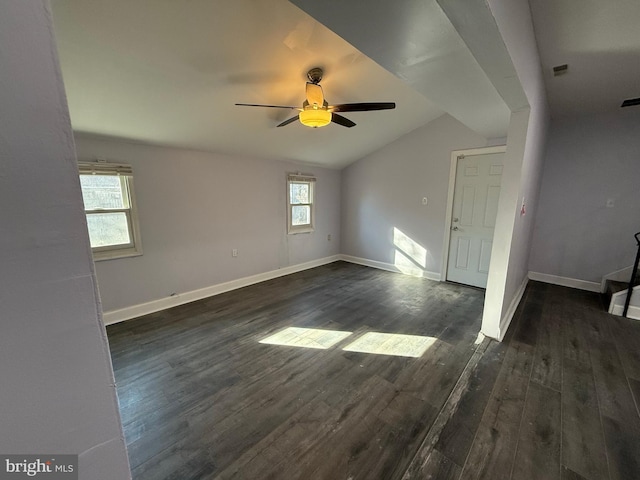 spare room with ceiling fan, a healthy amount of sunlight, dark hardwood / wood-style flooring, and vaulted ceiling