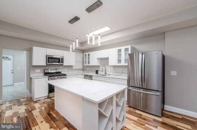 kitchen with sink, white cabinets, appliances with stainless steel finishes, and a kitchen island