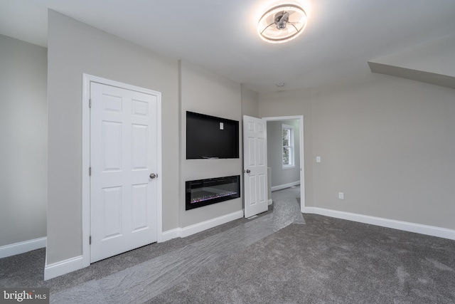 unfurnished living room with dark colored carpet