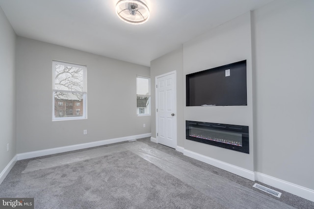 unfurnished living room featuring light colored carpet