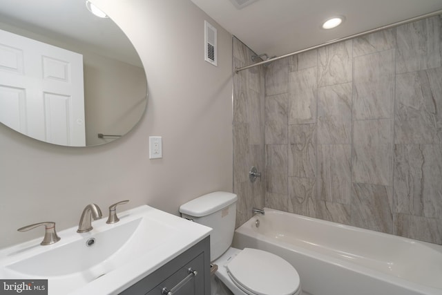 full bathroom featuring toilet, tiled shower / bath, and vanity