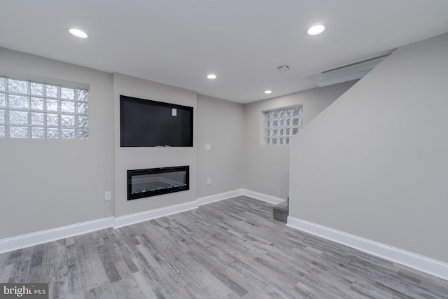 basement with light hardwood / wood-style flooring