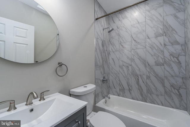 full bathroom featuring toilet, tiled shower / bath, and vanity