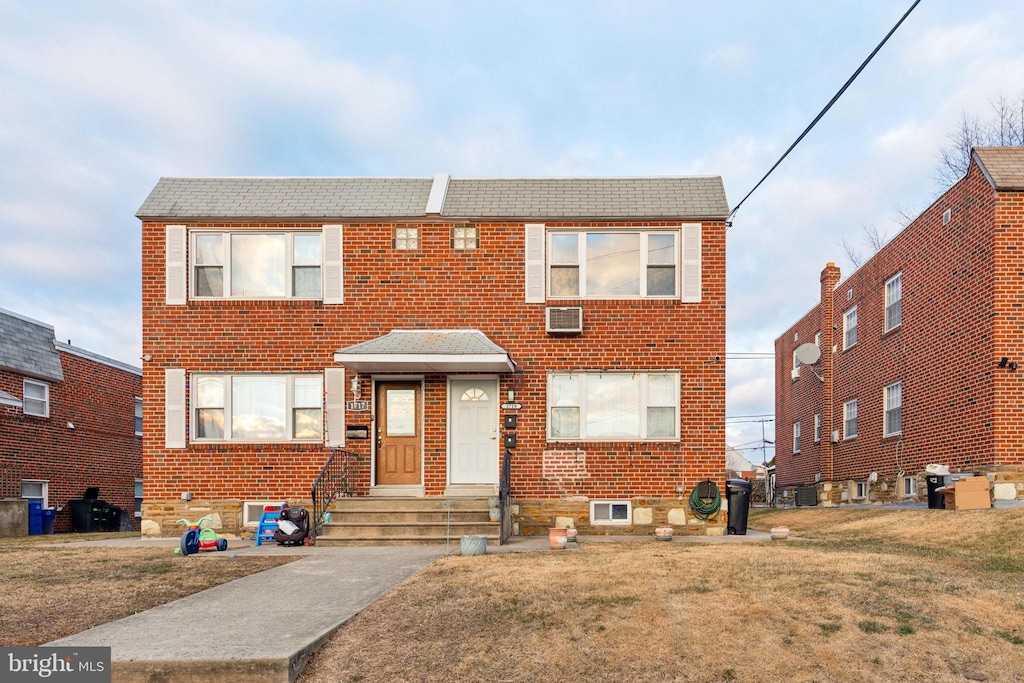 view of front facade featuring central AC and a front yard