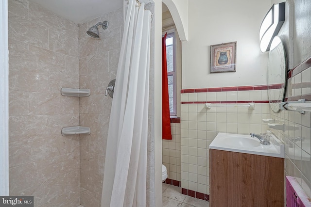 bathroom featuring vanity, toilet, tile walls, and curtained shower