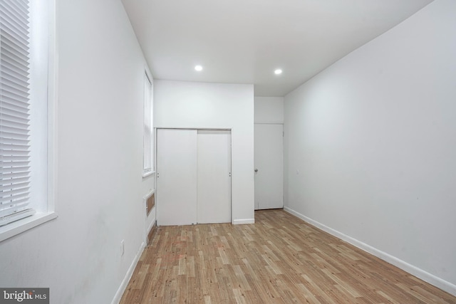 unfurnished bedroom featuring light wood-type flooring and a closet