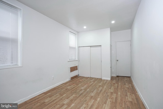 unfurnished bedroom featuring light wood-type flooring and a closet