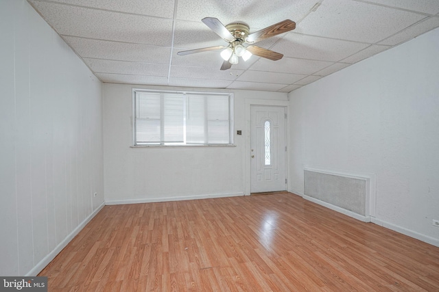 spare room with ceiling fan, a drop ceiling, and light wood-type flooring