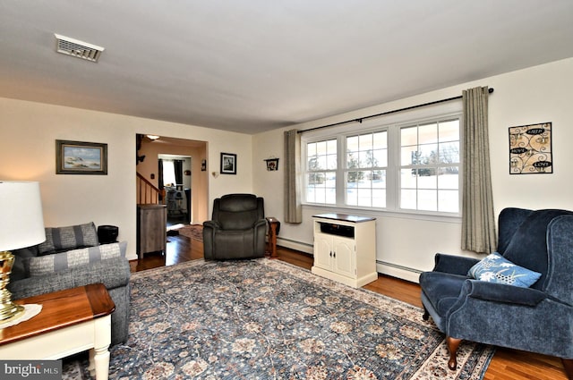 living room with hardwood / wood-style flooring and a baseboard heating unit