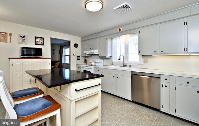 kitchen with a kitchen bar, sink, and appliances with stainless steel finishes