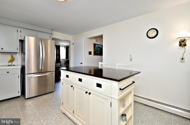 kitchen with stainless steel refrigerator, white cabinets, and a baseboard heating unit