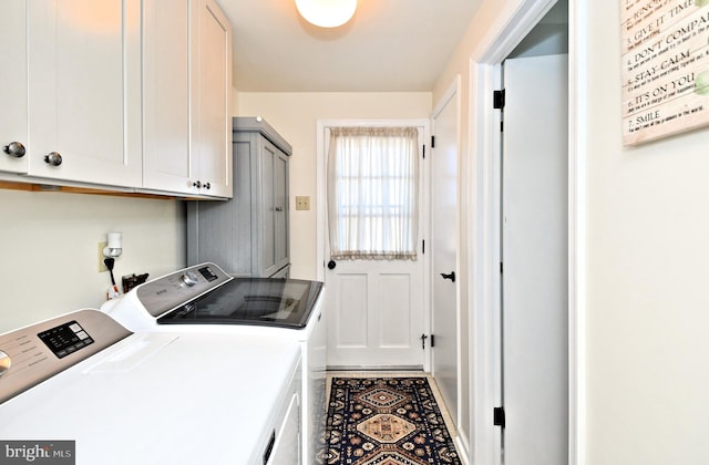 clothes washing area featuring separate washer and dryer and cabinets