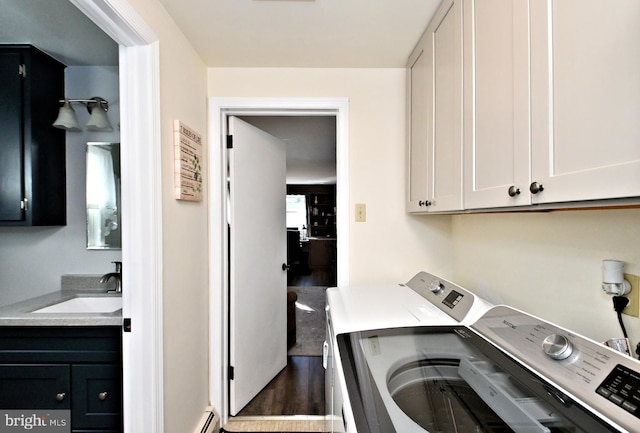 washroom featuring washer and clothes dryer, cabinets, baseboard heating, and sink