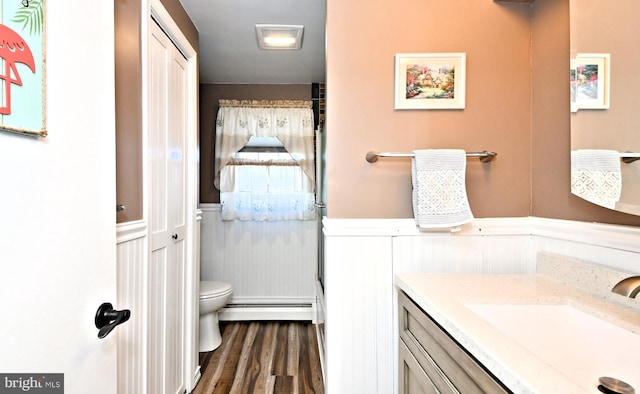 bathroom with hardwood / wood-style floors, vanity, a baseboard radiator, and toilet