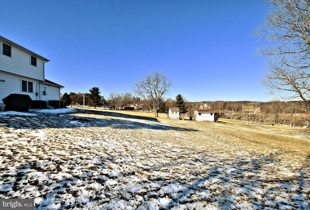 snowy yard with a storage shed