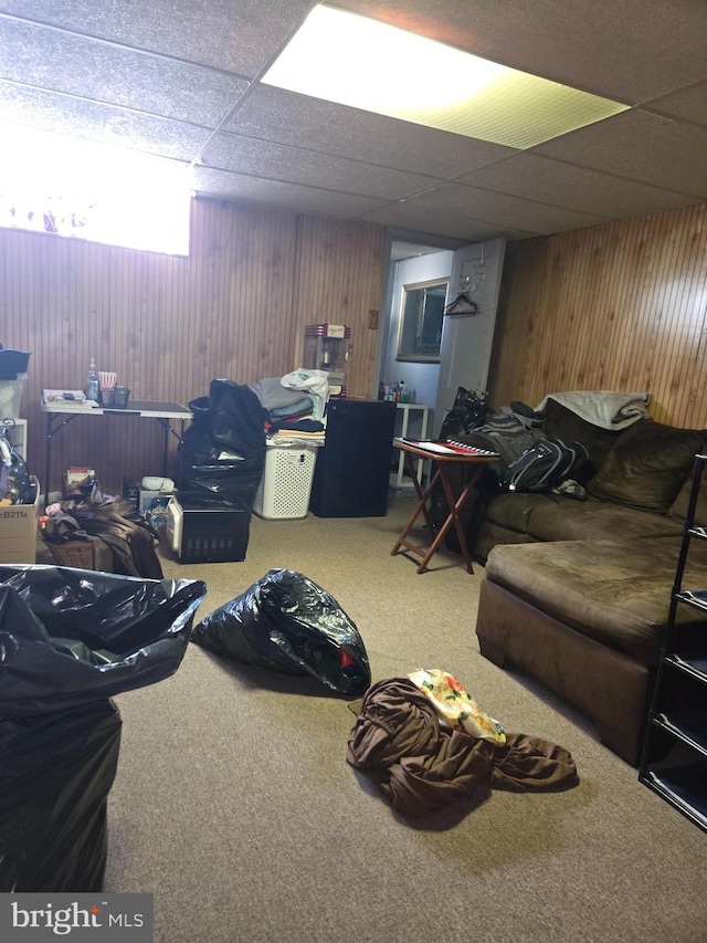 basement featuring a drop ceiling and carpet floors