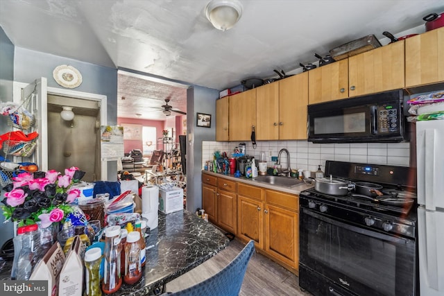 kitchen with sink, light hardwood / wood-style flooring, ceiling fan, backsplash, and black appliances