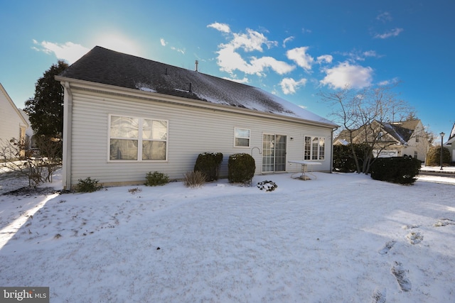 view of snow covered rear of property