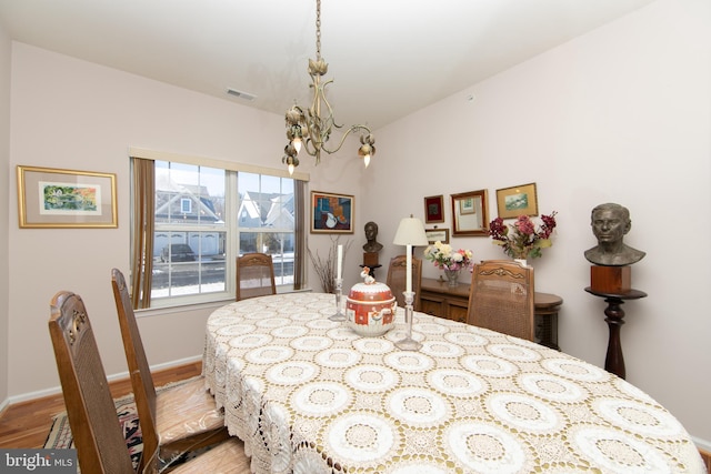 dining area featuring light hardwood / wood-style flooring and a notable chandelier