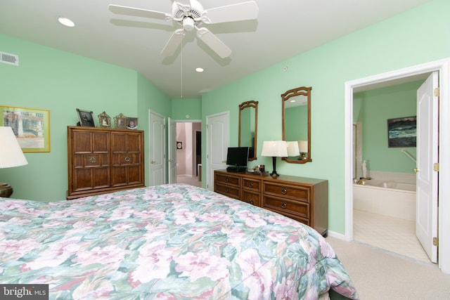 bedroom with ensuite bathroom, ceiling fan, and light carpet