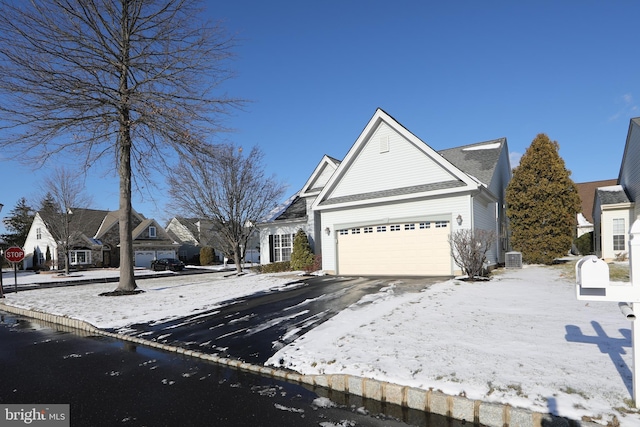 view of front facade with a garage and central AC