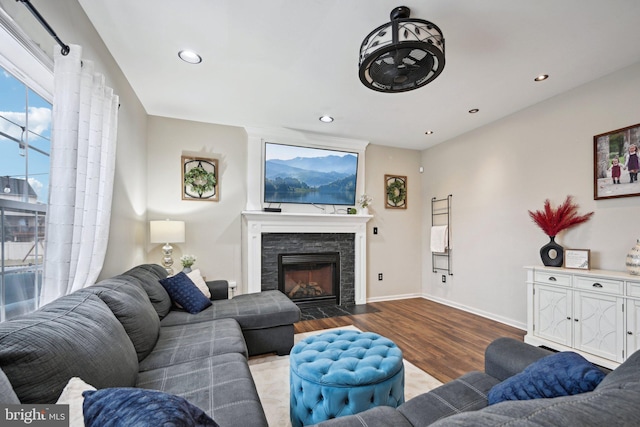 living room with a stone fireplace and light hardwood / wood-style floors