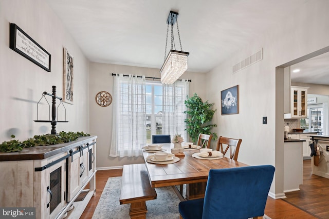 dining room with dark hardwood / wood-style floors and a notable chandelier