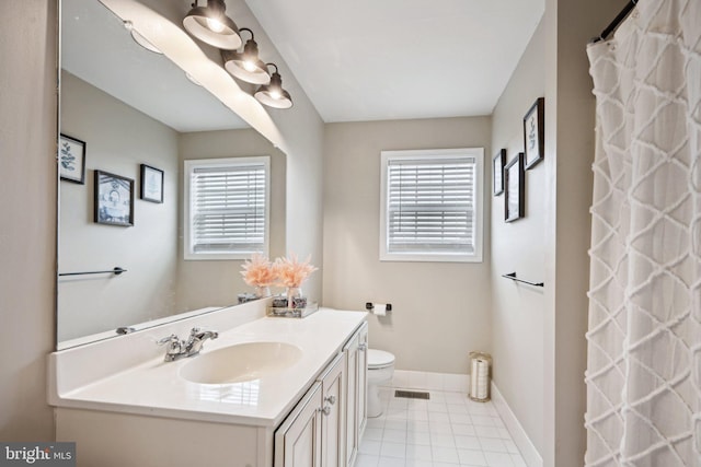 bathroom with tile patterned flooring, vanity, and toilet