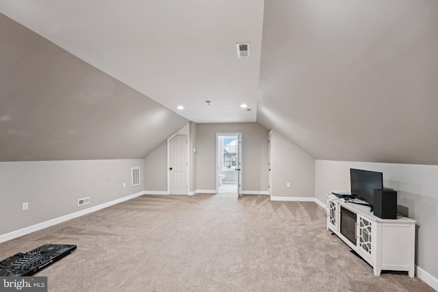 additional living space featuring light carpet and vaulted ceiling