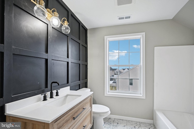 bathroom featuring vanity, toilet, and a tub