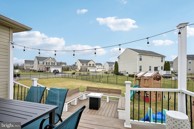 wooden terrace with a playground and a yard