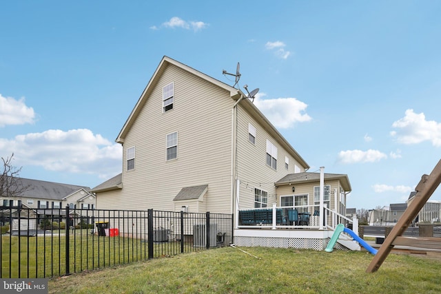 rear view of property featuring a yard and a wooden deck