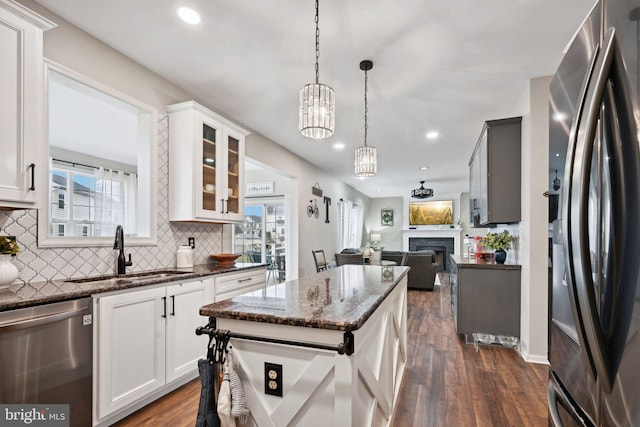 kitchen featuring white cabinetry, sink, a chandelier, and appliances with stainless steel finishes