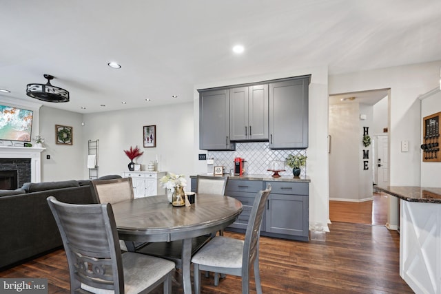 dining area featuring dark hardwood / wood-style flooring and a fireplace