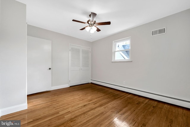 unfurnished bedroom featuring ceiling fan, light hardwood / wood-style flooring, and a baseboard radiator