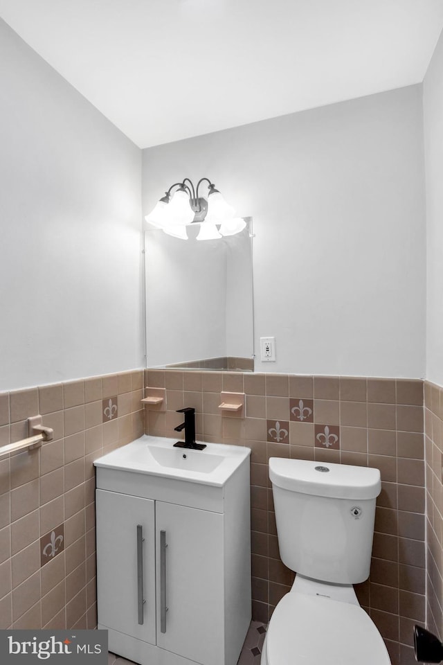 bathroom with vanity, tile walls, and toilet