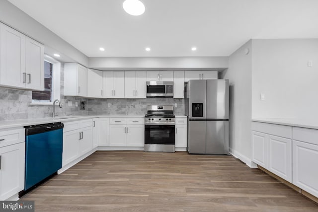 kitchen featuring white cabinets, sink, appliances with stainless steel finishes, and tasteful backsplash