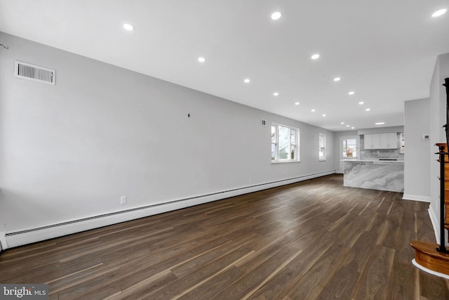 unfurnished living room with dark wood-type flooring and a baseboard radiator