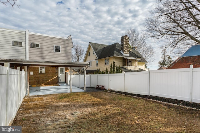 rear view of property with a patio and a lawn