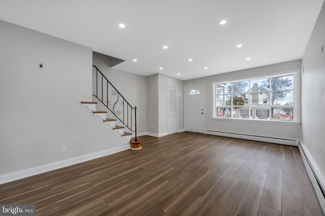 unfurnished living room featuring a baseboard radiator and dark hardwood / wood-style floors