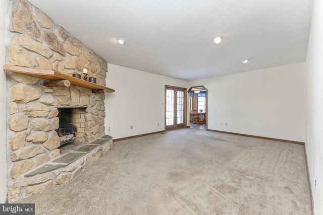 unfurnished living room with carpet, french doors, and a fireplace