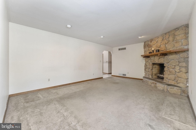 unfurnished living room with carpet and a fireplace