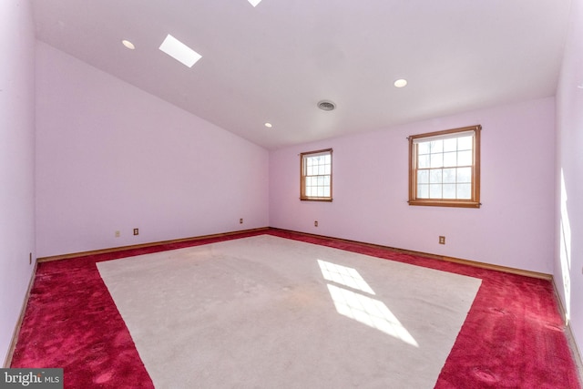 carpeted spare room with a wealth of natural light and lofted ceiling with skylight